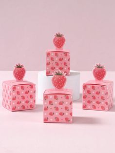 four pink boxes with strawberries on them