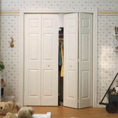 two teddy bears sitting on the floor in front of an open white closet with doors