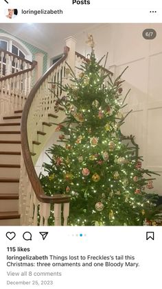 a christmas tree is in the middle of a staircase