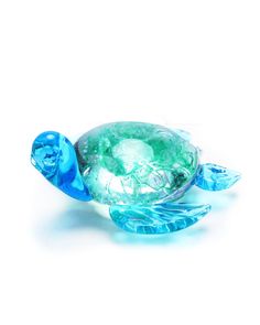 a glass turtle figurine sitting on top of a white surface