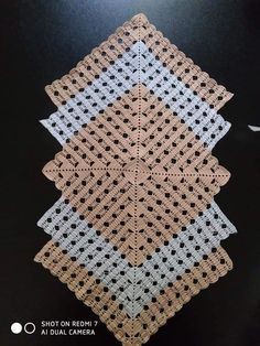 a crocheted doily is shown on a black surface