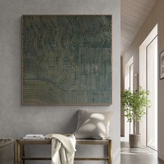 a painting hanging on the wall next to a bench with a blanket draped over it