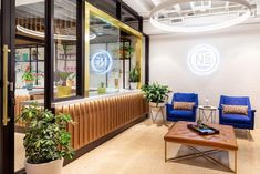 the inside of an office with two blue chairs and a coffee table in front of it