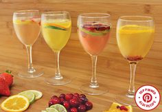 four wine glasses filled with different types of fruit