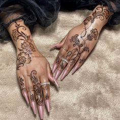 two hands with henna tattoos on them