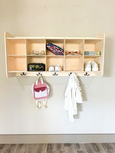 a coat rack with shoes and purses hanging from it's hooks on the wall