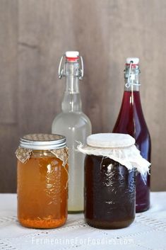 three jars filled with liquid sitting on top of a table