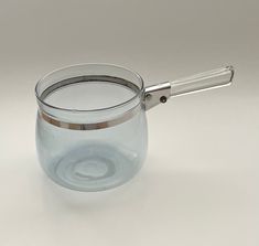 an empty glass cup with a metal handle