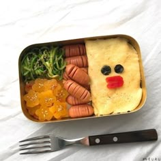 a bento box with carrots, broccoli and other food items