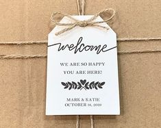 a welcome sign hanging from a string on a cardboard box with twine and rope