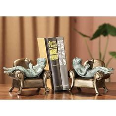 there is a bookend with two books on it and a statue of a person reading