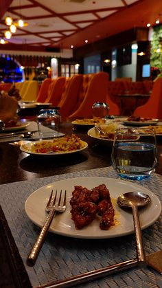 the table is set with silverware and plates of food