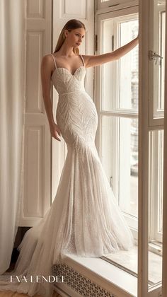 a woman in a wedding dress leaning on a window sill