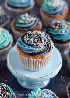 cupcakes with blue frosting and sprinkles on a plate