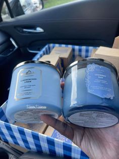 two blue candles sitting in the passenger seat of a car, with boxes behind them