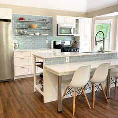 a kitchen with white cabinets and wooden floors