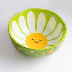 a green and white bowl with a smiley face on it