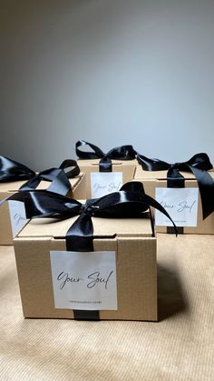 four boxes with black ribbon tied around them