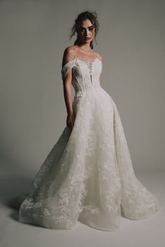 a woman in a white wedding dress posing for the camera with her hands on her hips