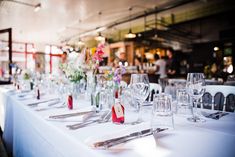 the table is set with empty wine glasses and place settings for guests to sit at