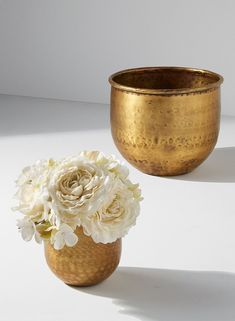 two gold vases with white flowers in them