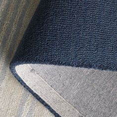 a close up view of a blue and white blanket on a couch with the corner stitched off