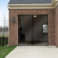 an open garage door in front of a brick building