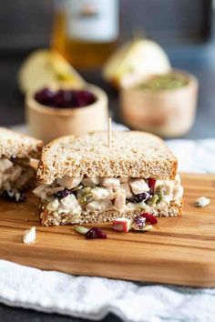 a sandwich cut in half sitting on top of a wooden cutting board