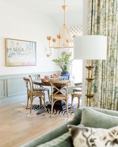 a dining room table and chairs in front of a window