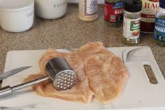 a cutting board with some meat on it and a grater in the middle of it