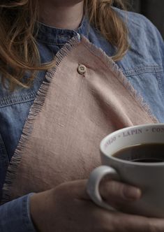 a close up of a person holding a cup of coffee