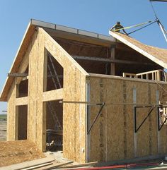 an unfinished house being built with workers on the roof