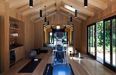 an exercise room with wooden walls and flooring is shown in this image, there are treadmills on each side of the wall