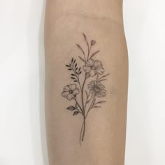 a black and white flower tattoo on the right arm, with leaves in blooming