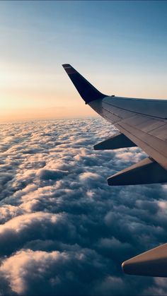 the wing of an airplane flying above clouds