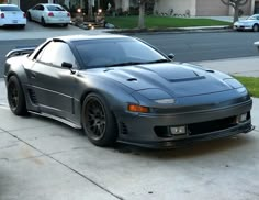 a gray sports car parked in front of a house