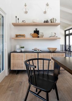 a black chair sitting in front of a wooden table