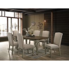 a dining room table with white chairs and a clock hanging on the wall behind it