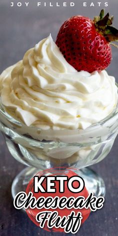 a close up of a dessert in a glass bowl with whipped cream and a strawberry on top