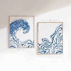 two blue and white paintings hanging on the wall