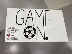 a paper sign that says game on with a soccer ball in the center and words saying, wishing you the best season