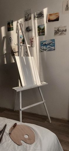 a white easel sitting on top of a bed