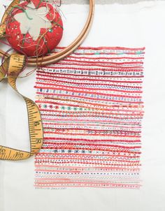 a piece of fabric with a measuring tape next to it and a red apple on top