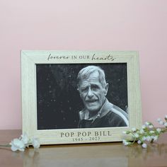 an old photo frame with the words, forever in our hearts on it next to some flowers