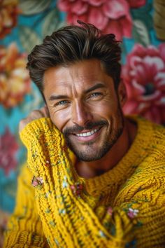 a man with a smile on his face wearing a yellow sweater