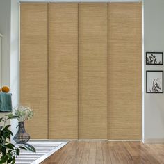 a living room with wooden floors and sliding glass doors that have blinds on the side