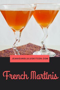 two glasses filled with orange liquid sitting on top of a wooden table next to each other