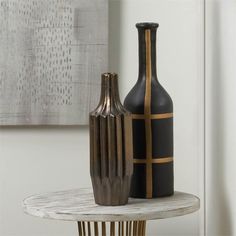 two black and gold vases sitting on a table