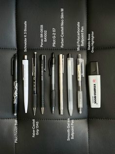 the contents of a black leather case with pens and writing utensils on it