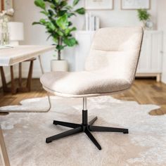 a white chair sitting on top of a rug in front of a table and chairs